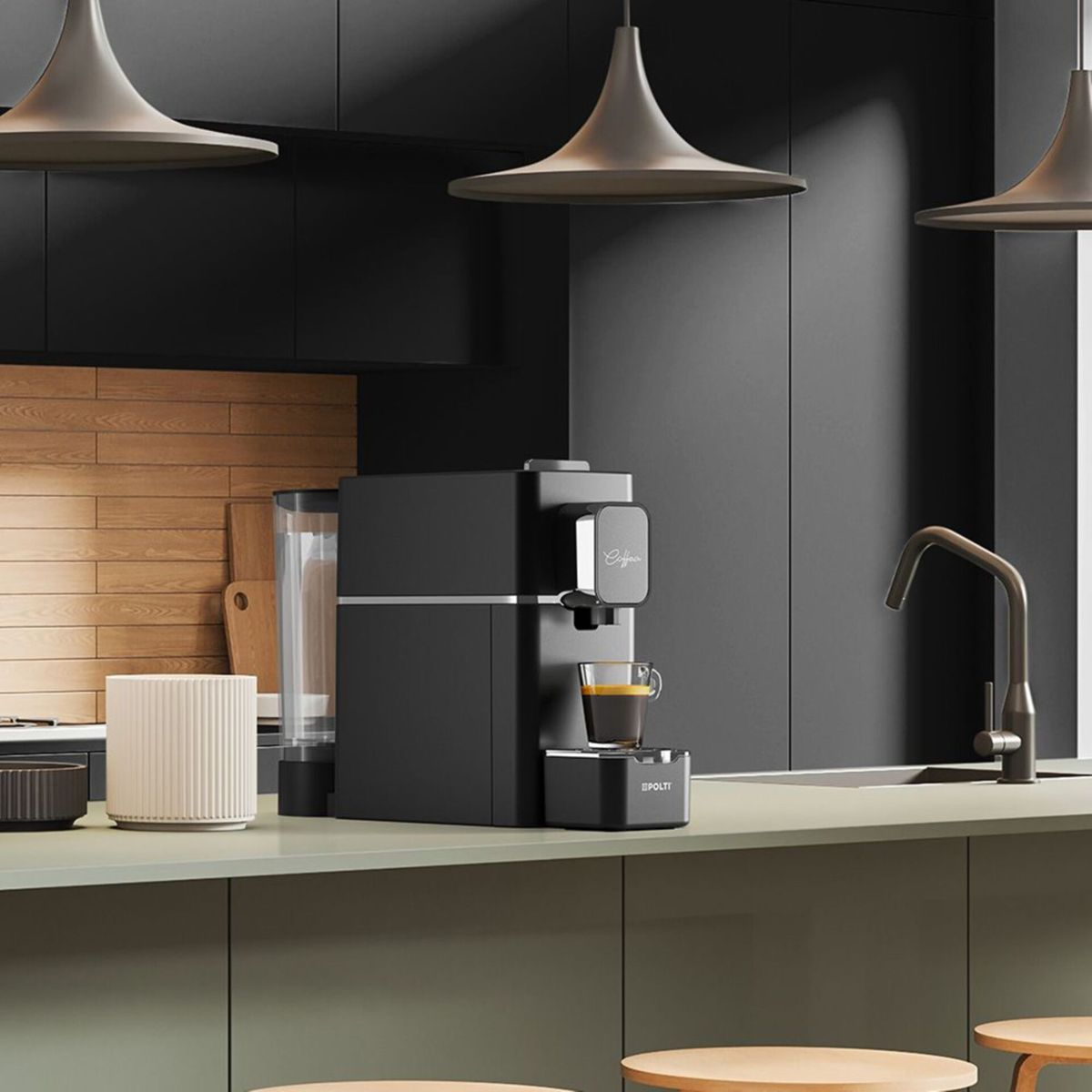 Eine schwarze Kaffeemaschine auf einer Küchentheke mit einer Tasse Espresso, darüber Hängeleuchten und dunkle Schränke.