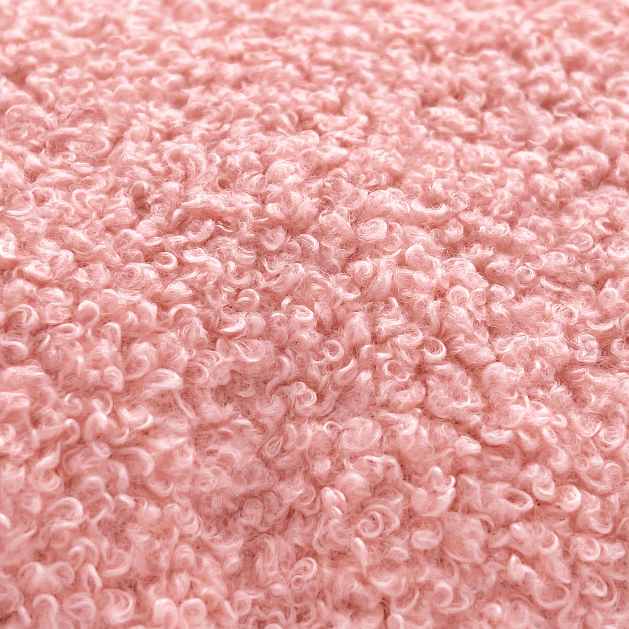 Nahaufnahme einer flauschigen rosa Teddystoff-Textur mit lockigen Fasern.