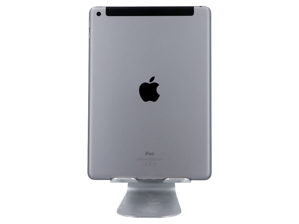 Tył szarego iPada z logo Apple na srebrnym metalowym stojaku na białym tle.