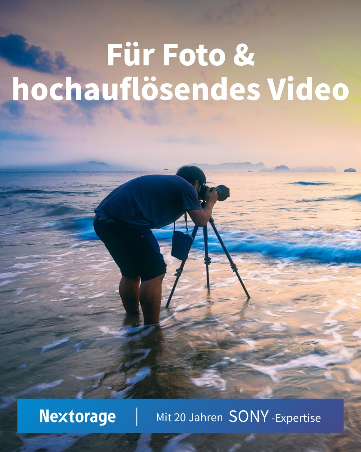 Un photographe avec un trépied se tient dans de l'eau peu profonde et photographie le lever du soleil.