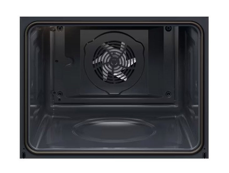 L'interno di un forno scuro con una ventola di convezione argentata sulla parete di fondo.
