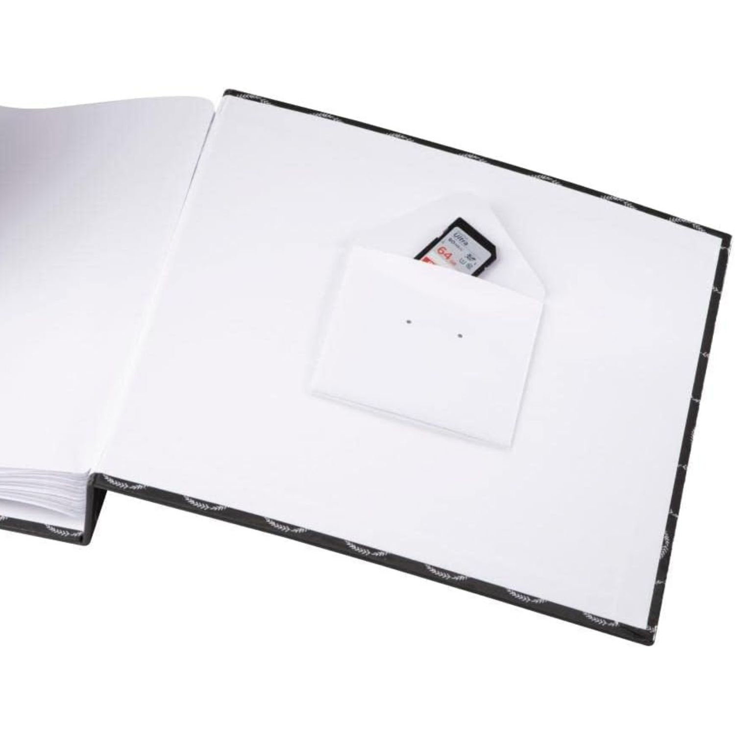 Un álbum de fotos abierto con un pequeño sobre blanco que contiene una tarjeta de memoria.