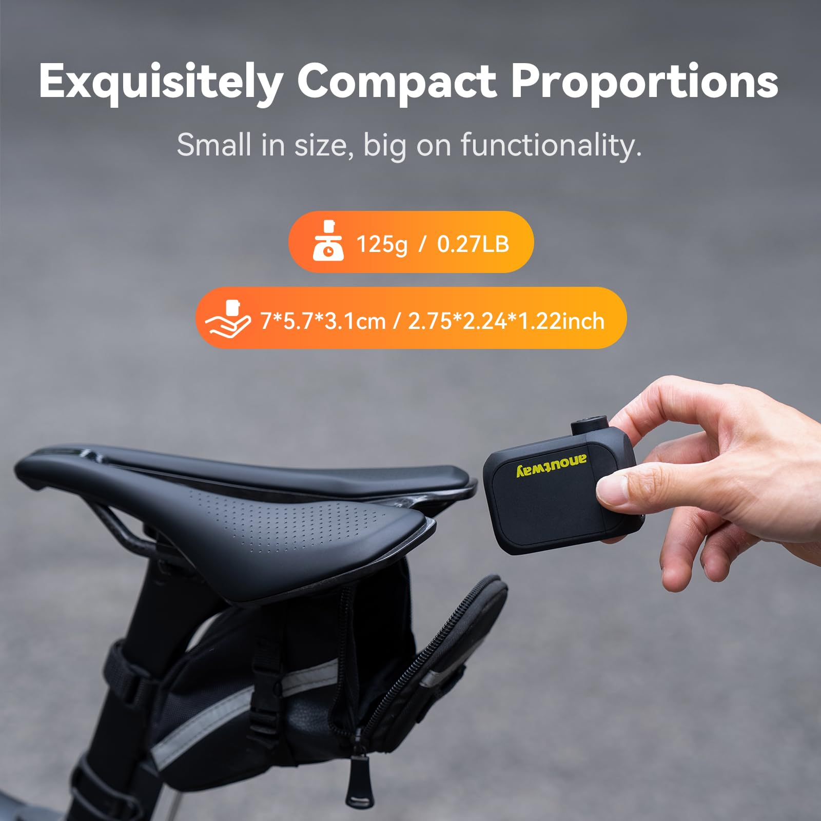 Eine Hand hält ein kompaktes schwarzes Gerät neben einem Fahrradsattel mit Tasche.