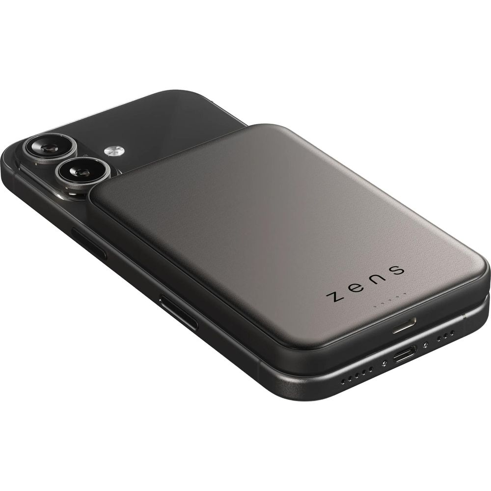 A black Zens magnetic power bank attached to the back of a dark smartphone on a white background.