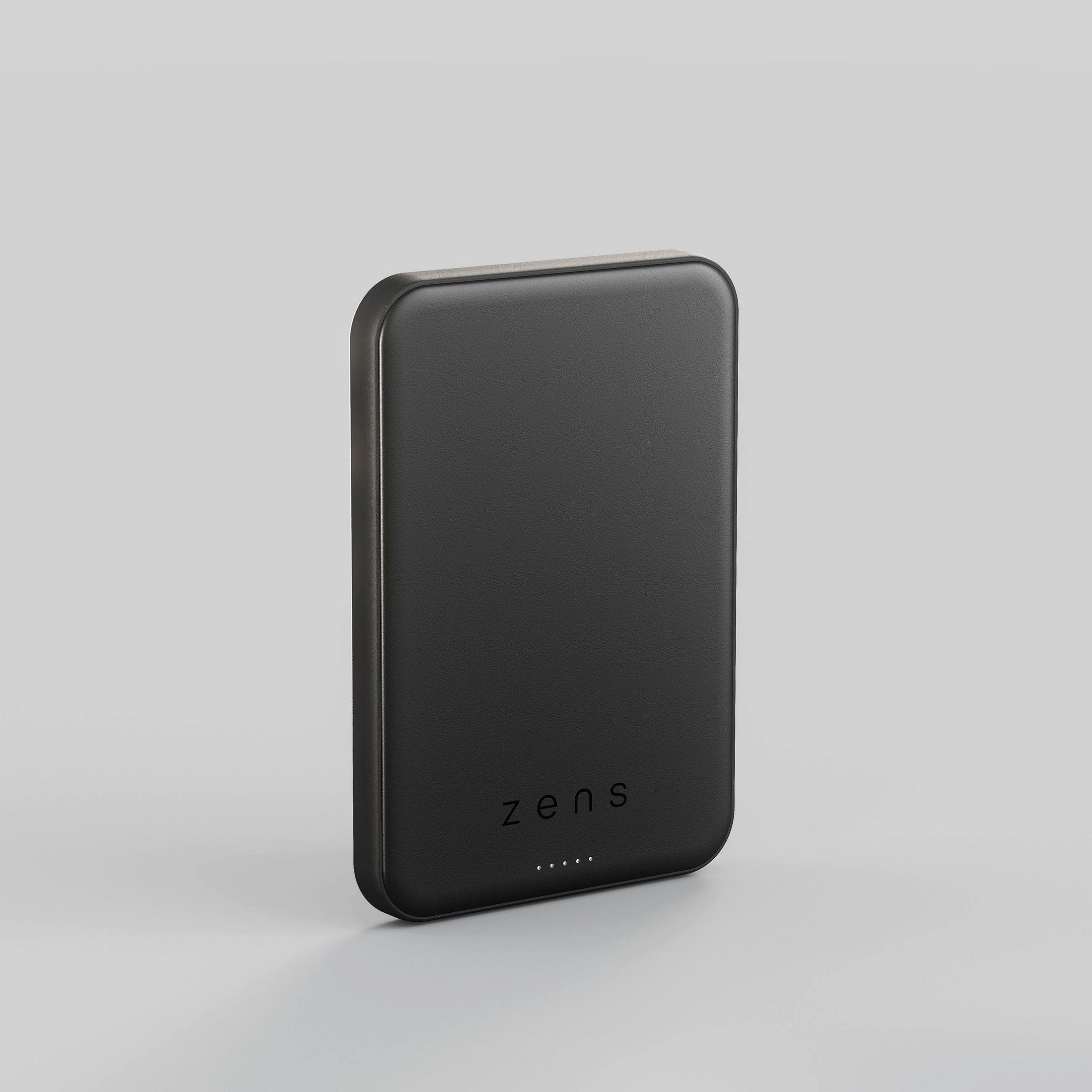 A rectangular black Zens power bank with rounded corners and five small LED lights at the bottom on a gray background.