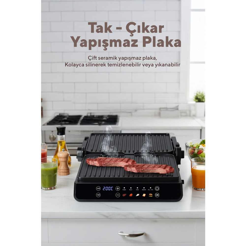 Mutfak tezgahında buharları tüten iki bifteği pişiren elektrikli bir ızgara.