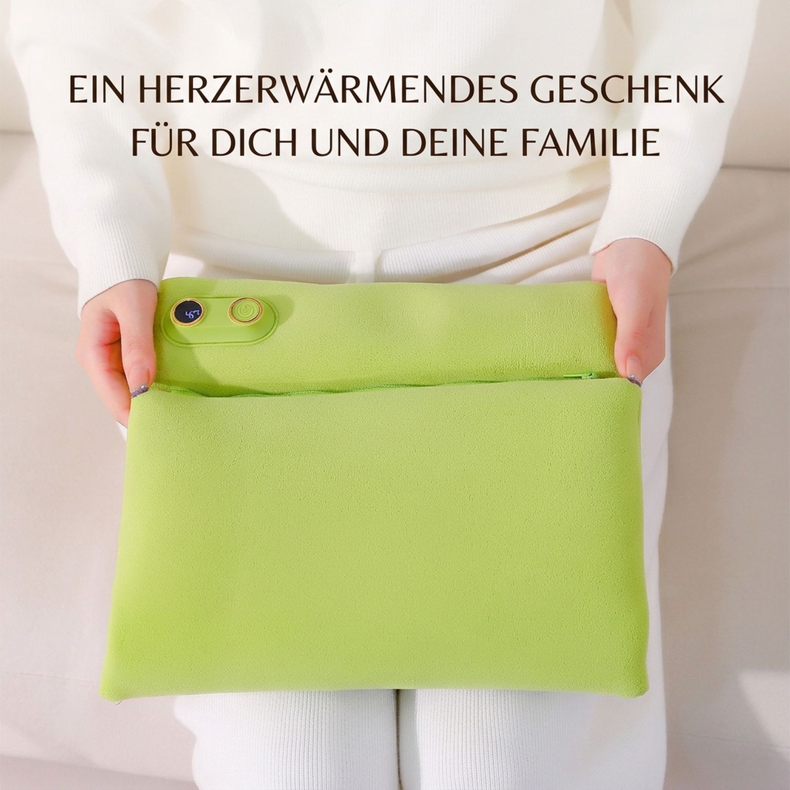 Eine Person hält ein hellgrünes, elektrisches Handwärmkissen mit Anzeige auf dem Schoß.