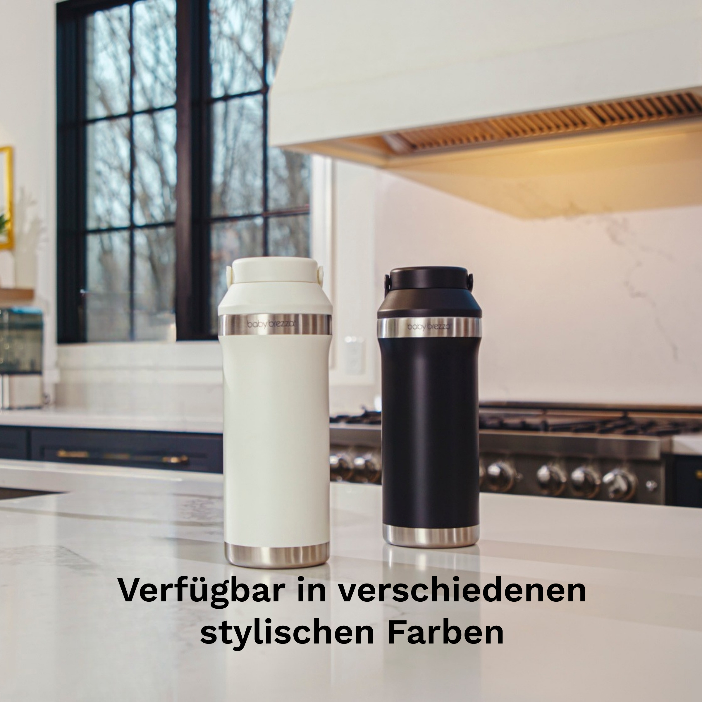 Eine weiße und eine schwarze Baby Brezza Thermosflasche stehen auf einer Marmorarbeitsplatte in einer Küche.