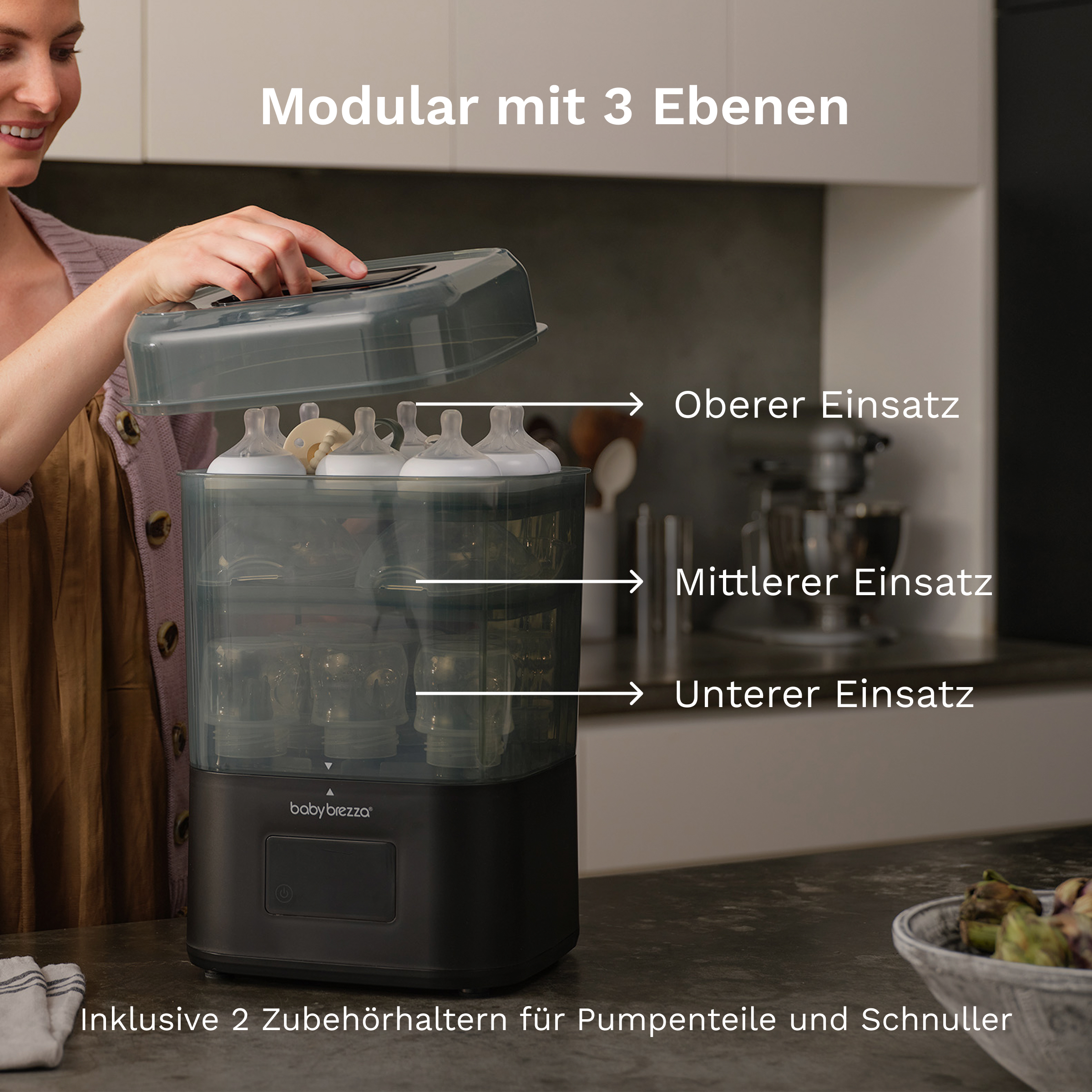 Eine Frau öffnet einen dreistöckigen Babyflaschen-Sterilisator auf einer Küchenarbeitsplatte.