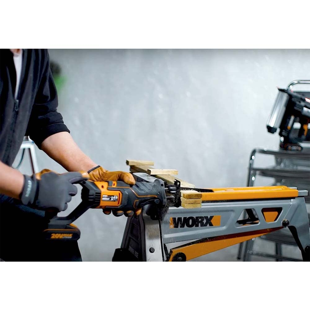 Eine Person mit Arbeitshandschuhen schneidet Holz auf einem Worx-Sägebock mit einer schwarzen und orangen Säge.