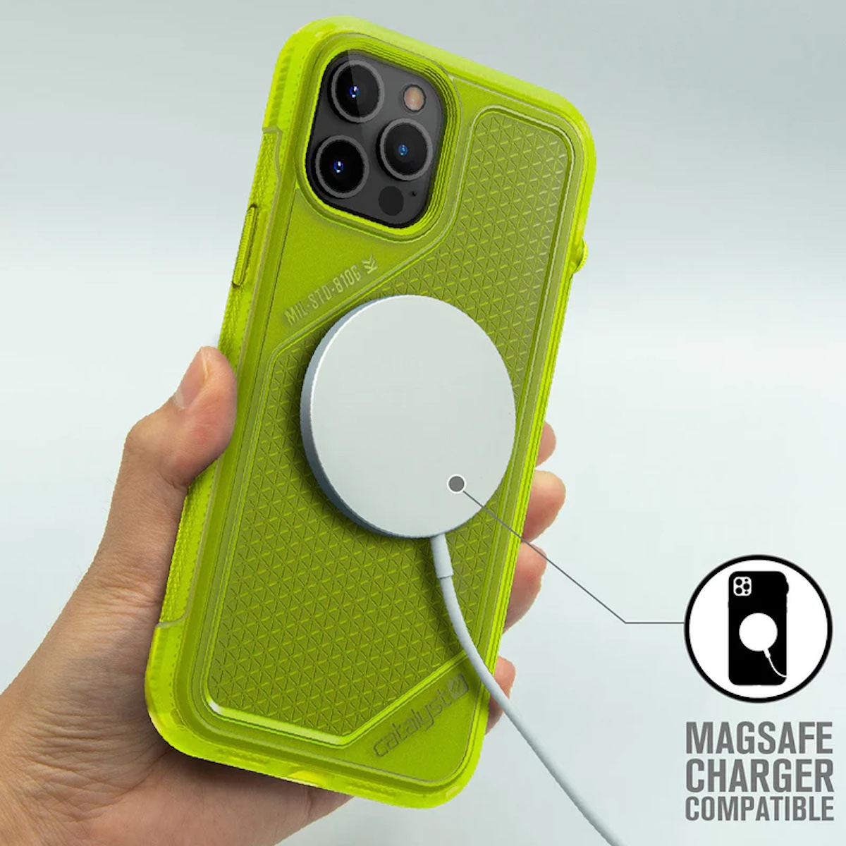 Hand hält ein grünes iPhone mit MagSafe-Ladegerät auf weißem Grund, mit Text Magsafe Charger Compatible.