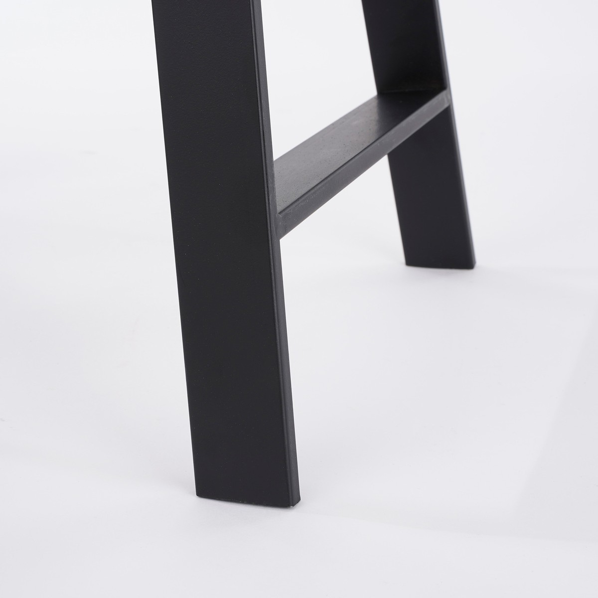 Schwarze, matte Metallbeine eines Möbels auf hellem Hintergrund.