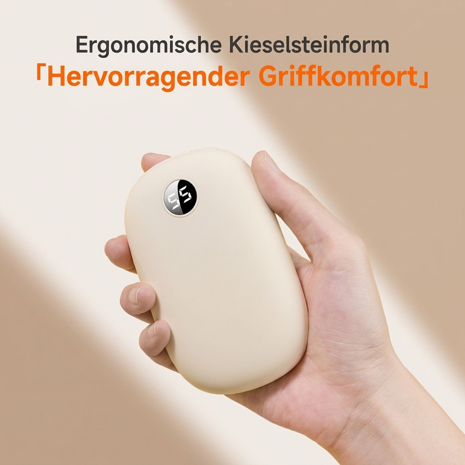 Eine Hand hält ein ovales, cremefarbenes Handwärmegerät mit einer digitalen Temperaturanzeige vor beigem Hintergrund.