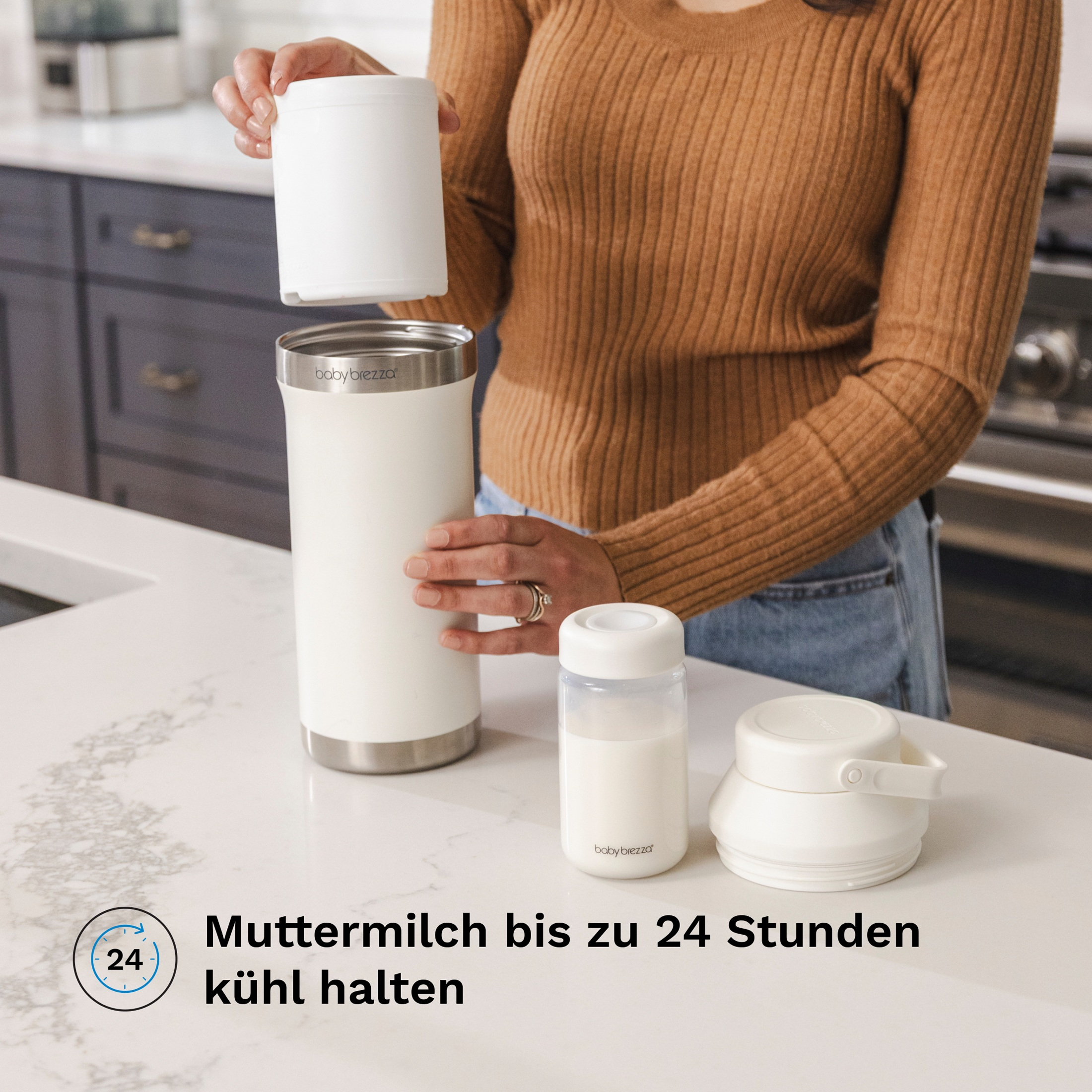 Eine Frau in braunem Pullover öffnet eine weiße Baby Brezza Milchkühlbox auf einer Küchenarbeitsplatte.