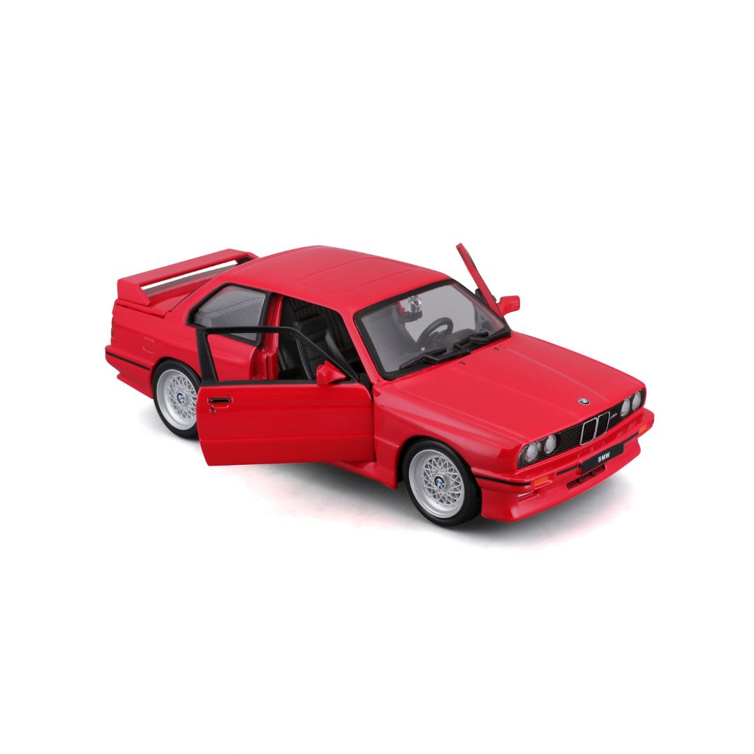Beyaz arka planda kapıları açık kırmızı bir BMW M3 E30 model arabası.
