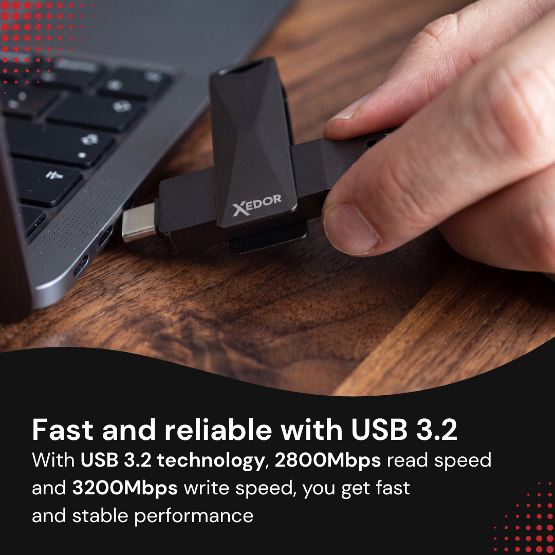 A hand plugs a black Xedor USB-C flash drive into a laptop on a wooden desk.