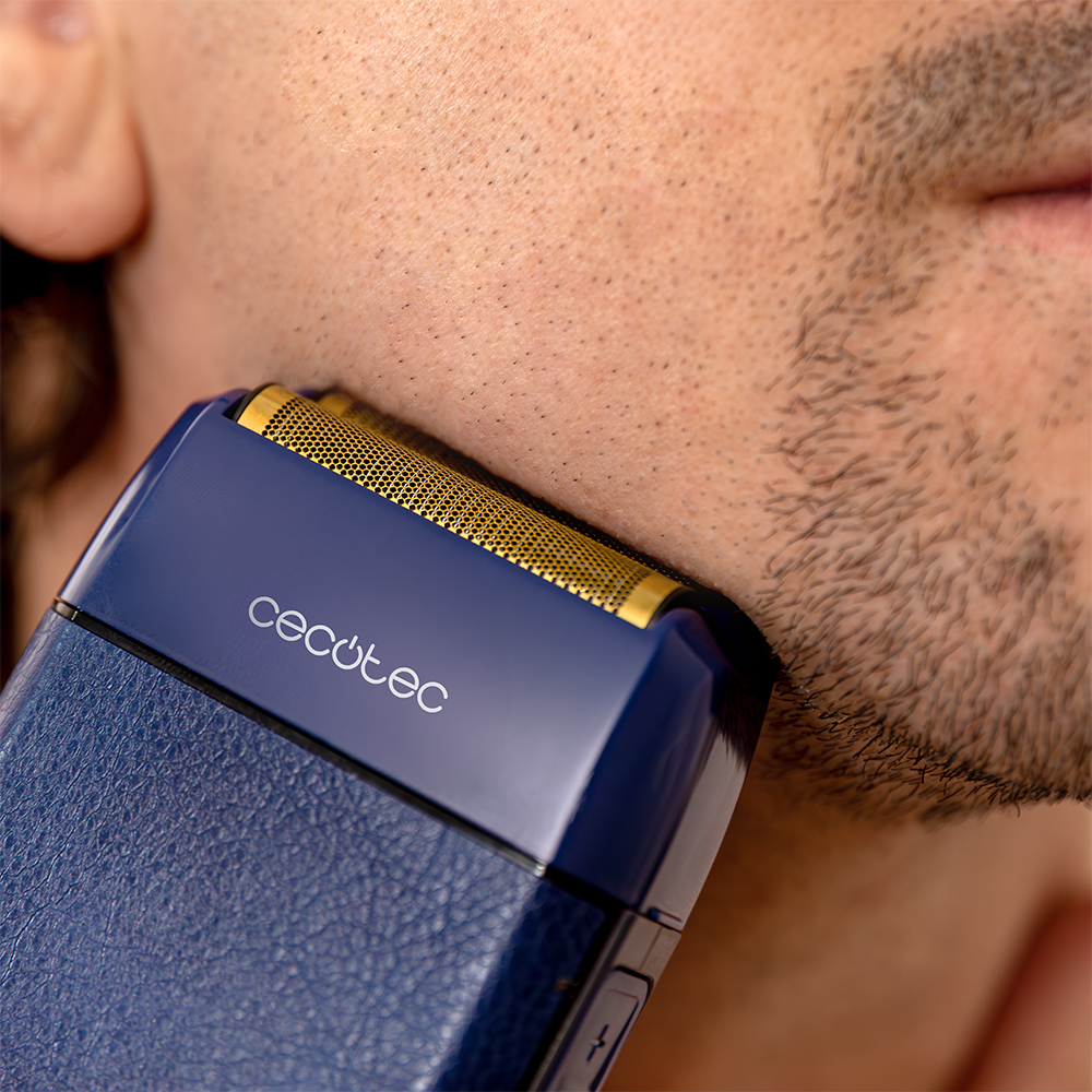 Una afeitadora azul Cecotec afeita la barba de la cara de un hombre.