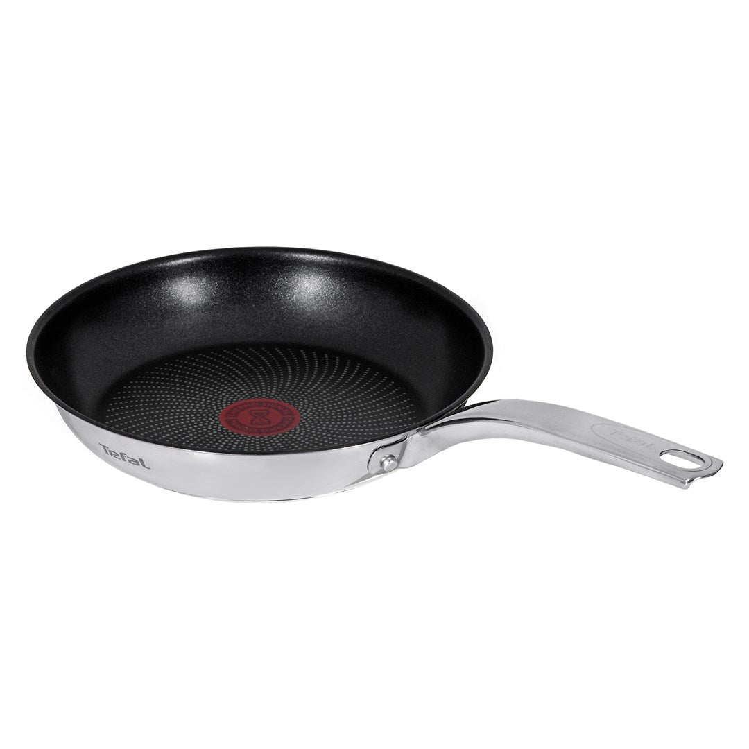 A Tefal frying pan with stainless steel body, black non-stick interior, and red thermo-signal in the center.
