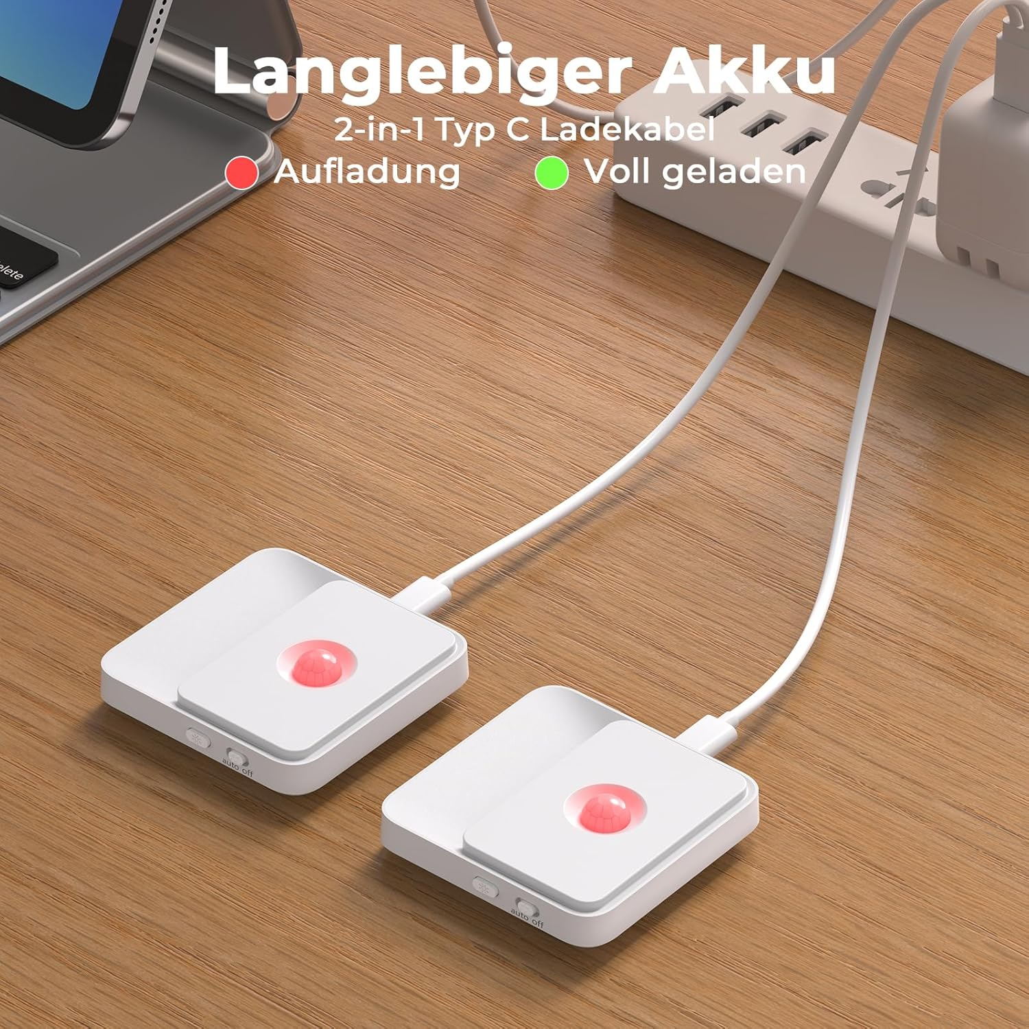 Zwei weiße Sensorgeräte mit rotem Licht werden auf einem Holz Tisch von einem USB-Kabel geladen.