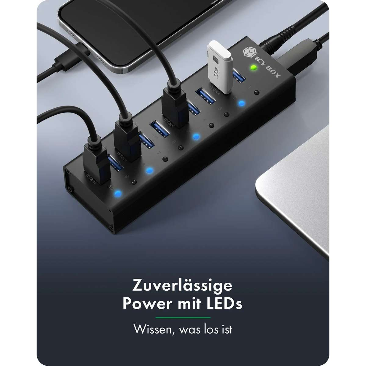 Schwarzer Icy Box USB-Hub mit eingesteckten Kabeln und blauen LED-Leuchten auf einem Schreibtisch.