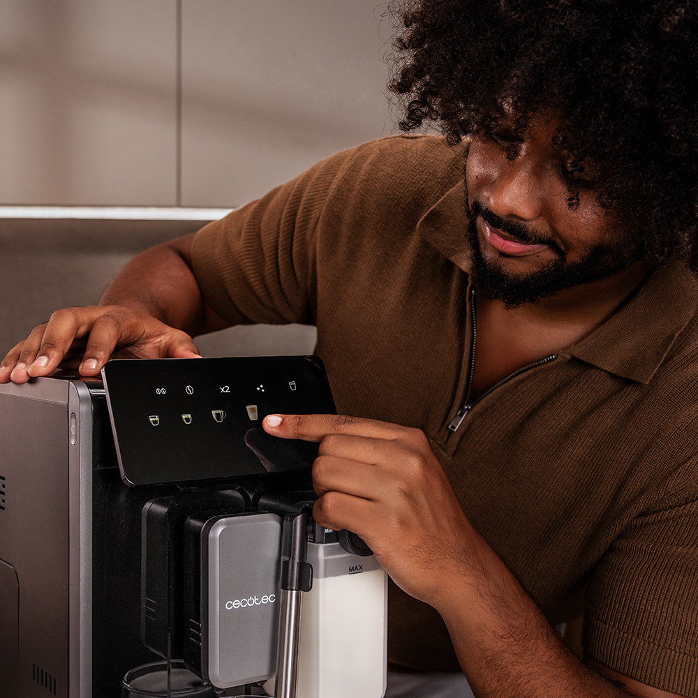 Ein Mann mit lockigem Haar bedient die Touchscreen-Anzeige einer Kaffeemaschine.