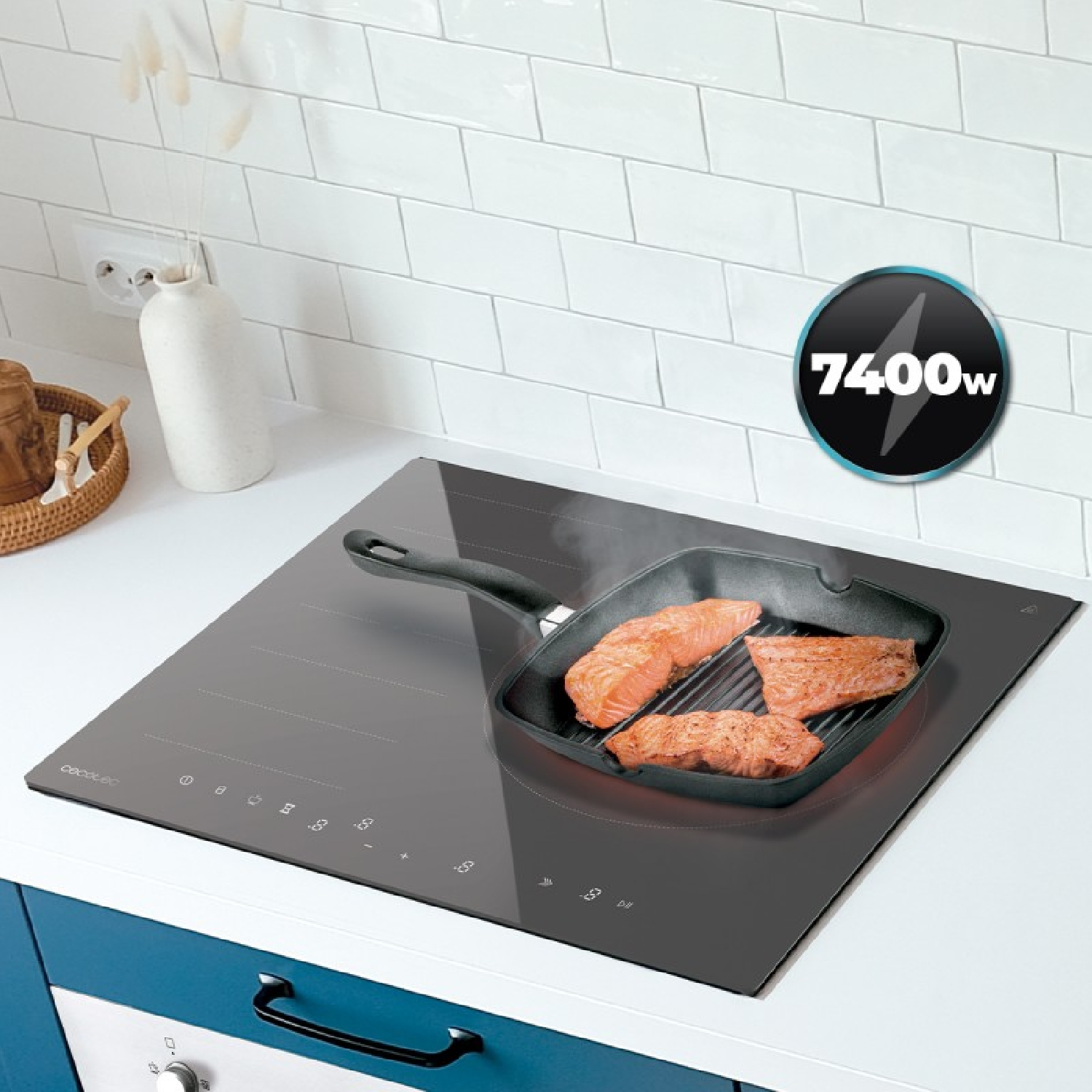Filetes de salmón cocinándose en una sartén grill sobre una placa de inducción negra en una cocina luminosa.