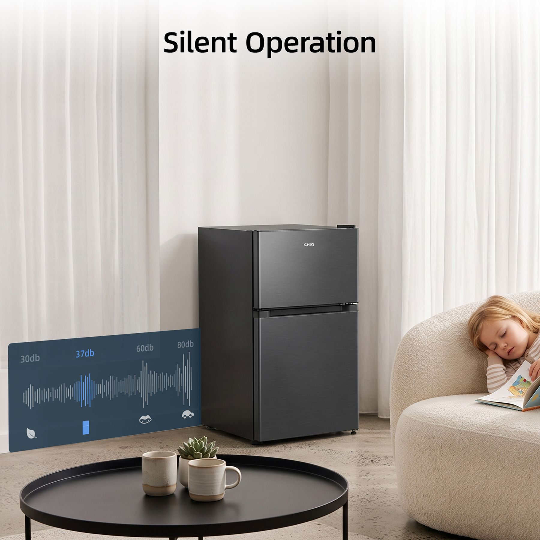 A child sleeps peacefully on an armchair next to a silent black refrigerator.