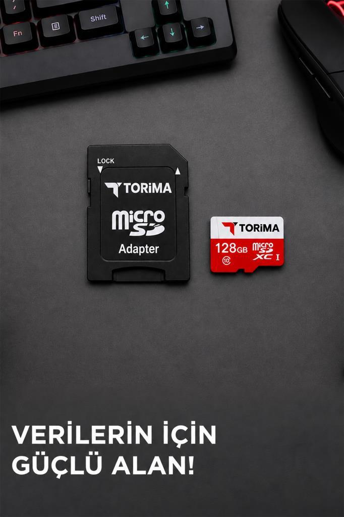 Koyu renkli bir masada klavyenin yanında bir Torima 128GB mikro SD kart ve SD adaptör duruyor.