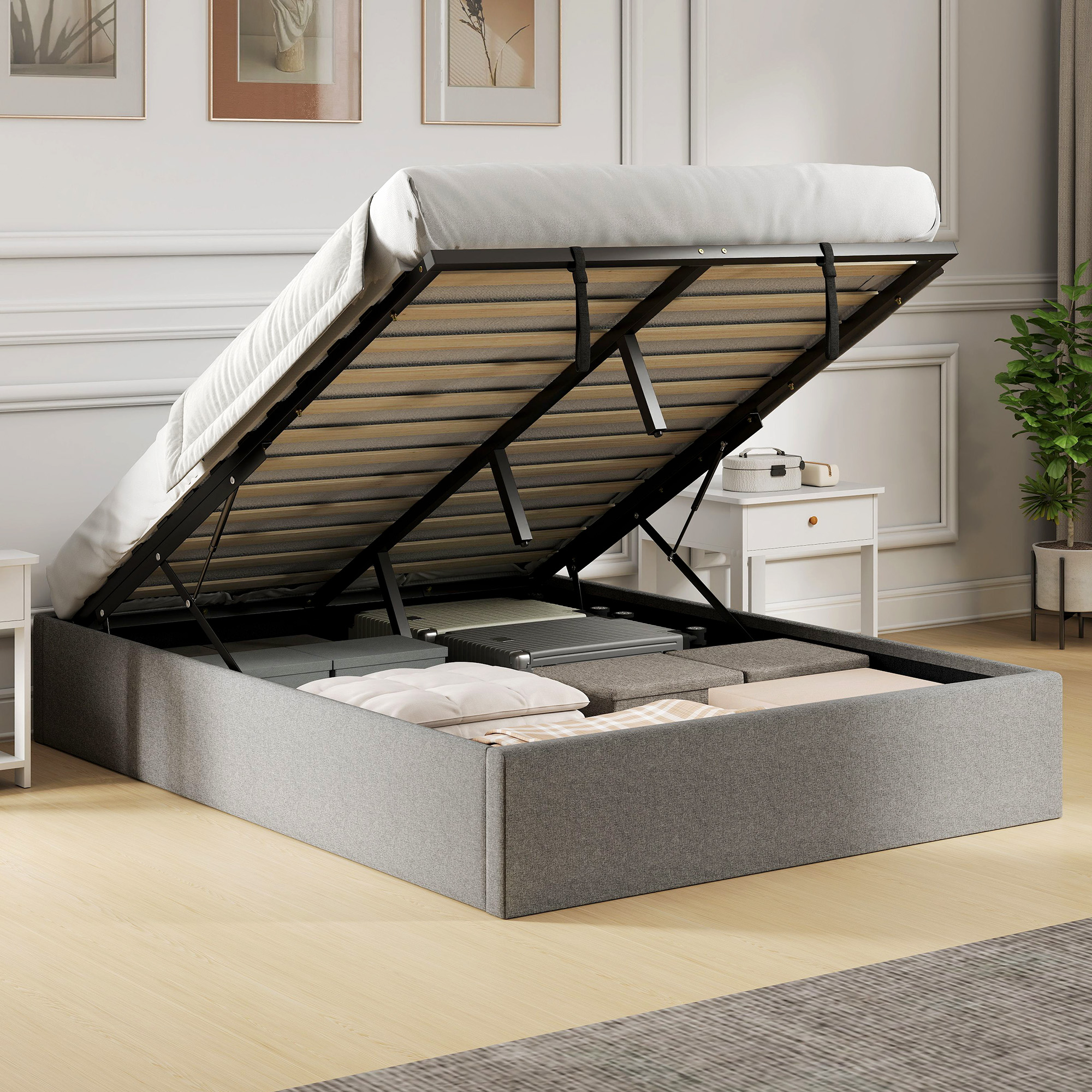 Una cama gris con somier levantado muestra espacio de almacenamiento debajo en una habitación luminosa.