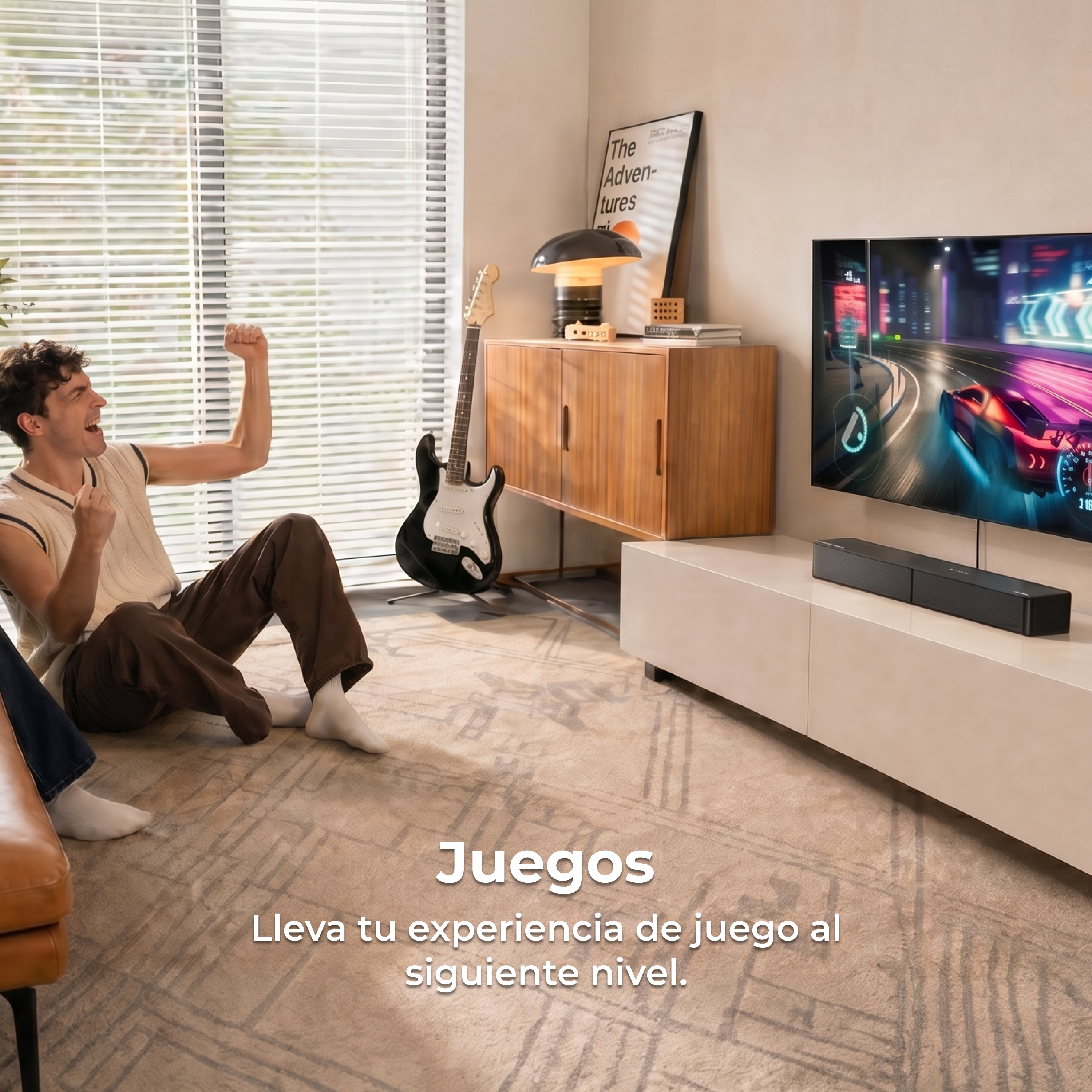 Un hombre sentado en una alfombra celebra mientras juega a un juego de carreras en un televisor grande en una sala luminosa.