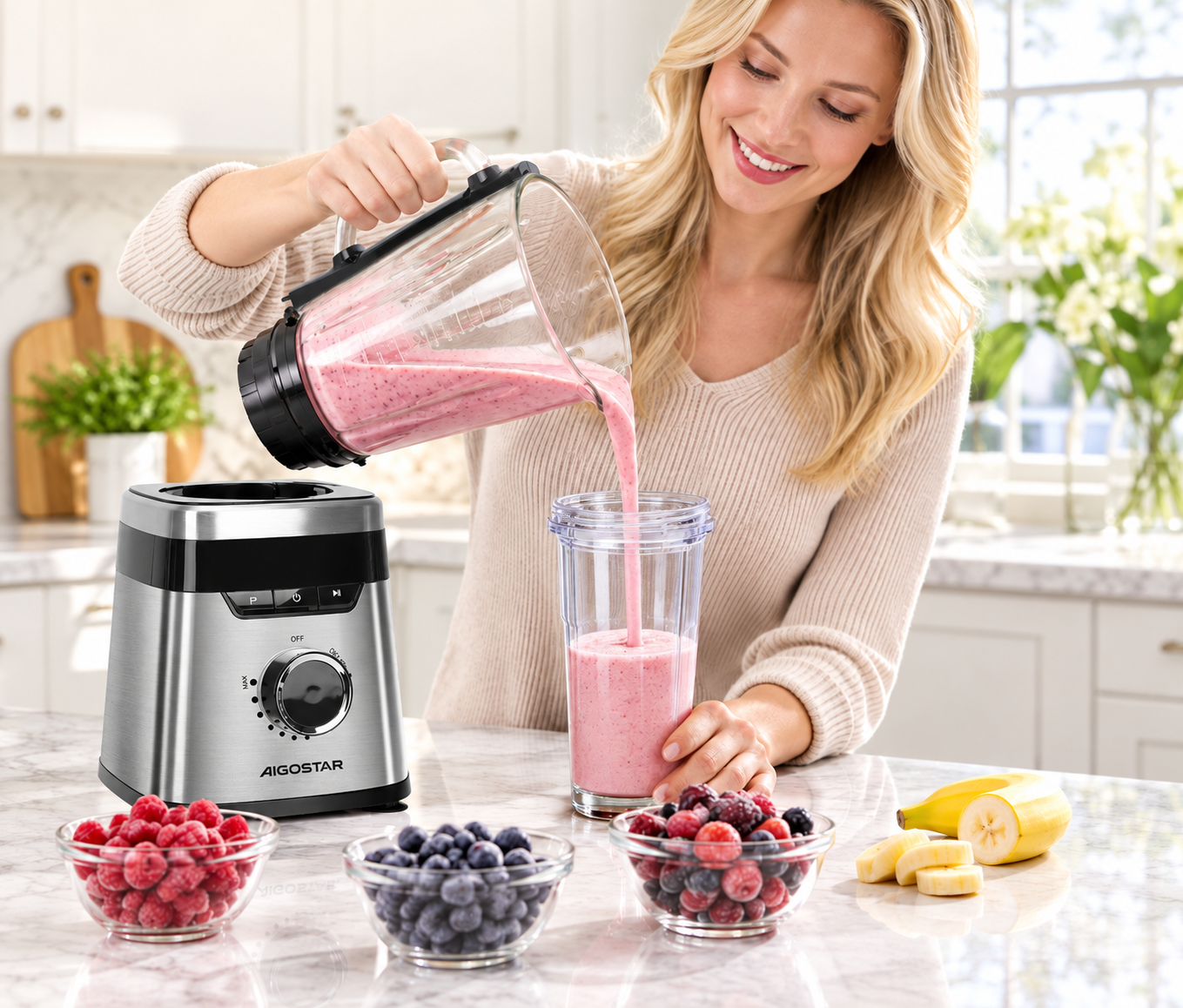 Eine lächelnde Frau gießt einen rosa Smoothie aus einem Mixerglas in einen Becher, umgeben von Beeren und Bananen.