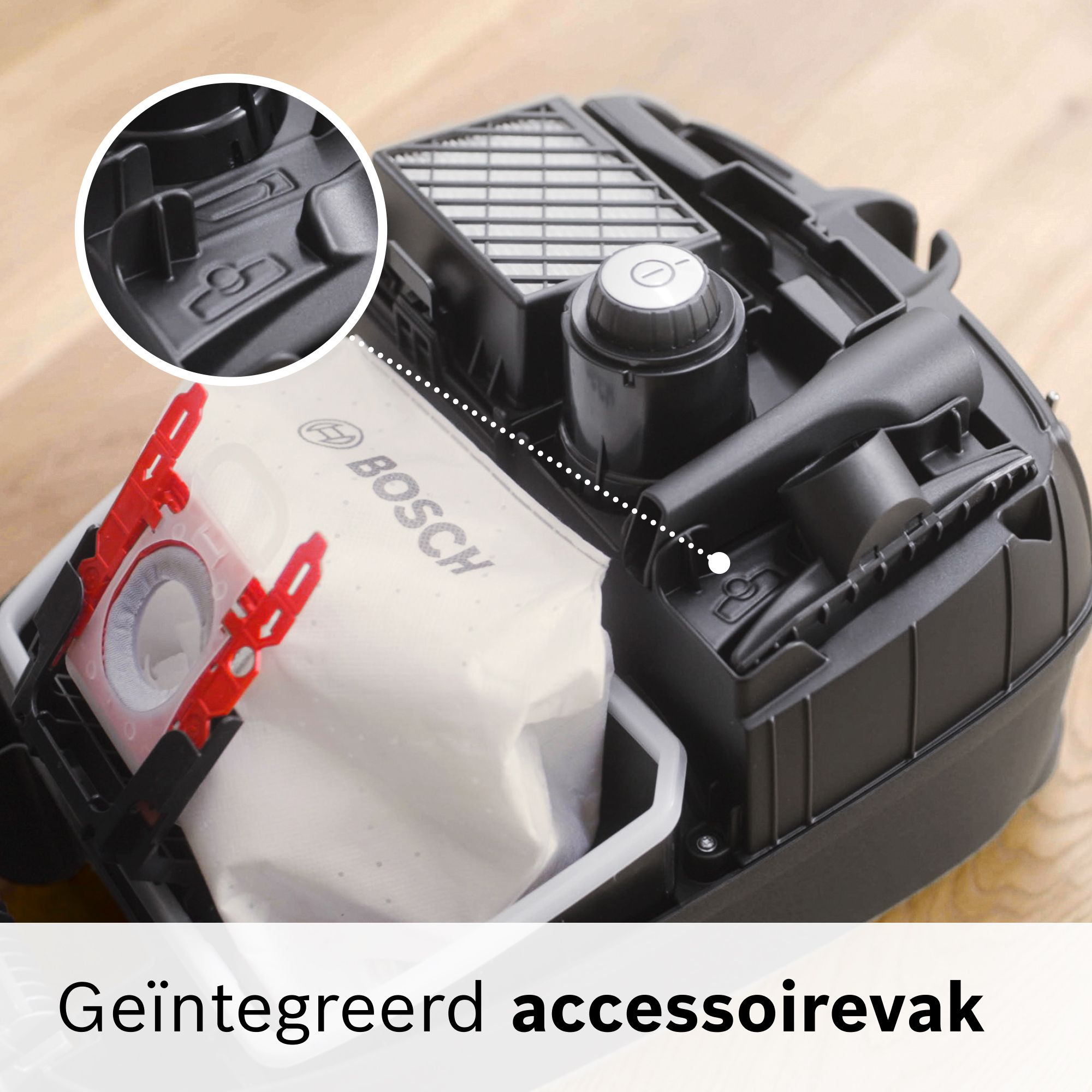 Interior view of a Bosch vacuum cleaner with dust bag, filter, and integrated accessory compartment.