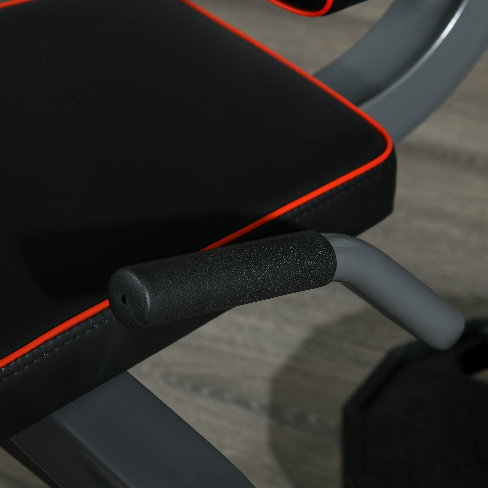 Primer plano de un banco de fitness con tapicería negra, ribete rojo y patas de metal gris.