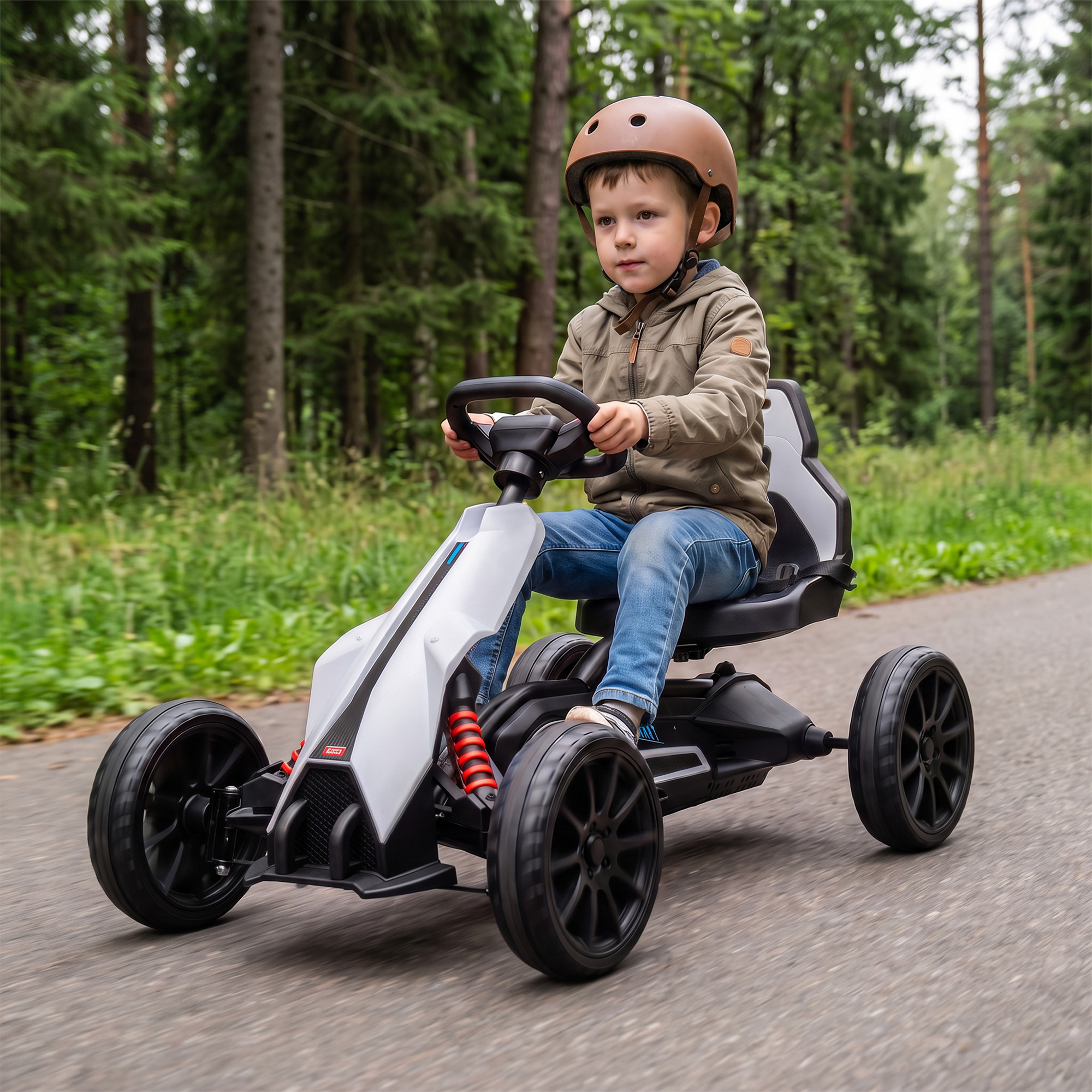 Un niño con casco conduce un kart blanco y negro por un camino asfaltado en un bosque.