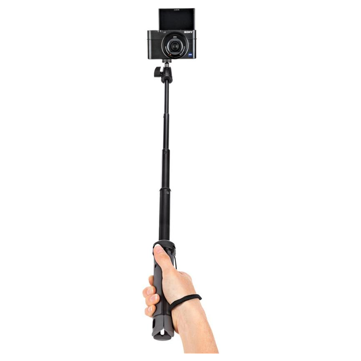Eine Hand hält einen schwarzen Selfiestick mit einer montierten Kamera vor einem weißen Hintergrund.