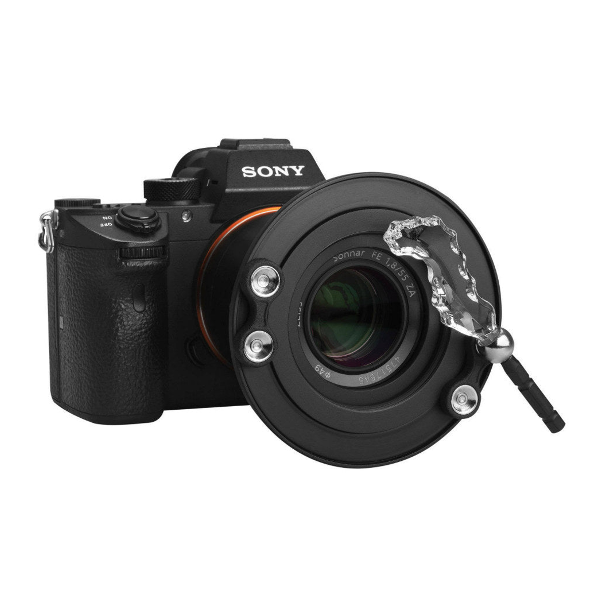 Fotocamera Sony nera con obiettivo collegato e prisma di cristallo su sfondo bianco.