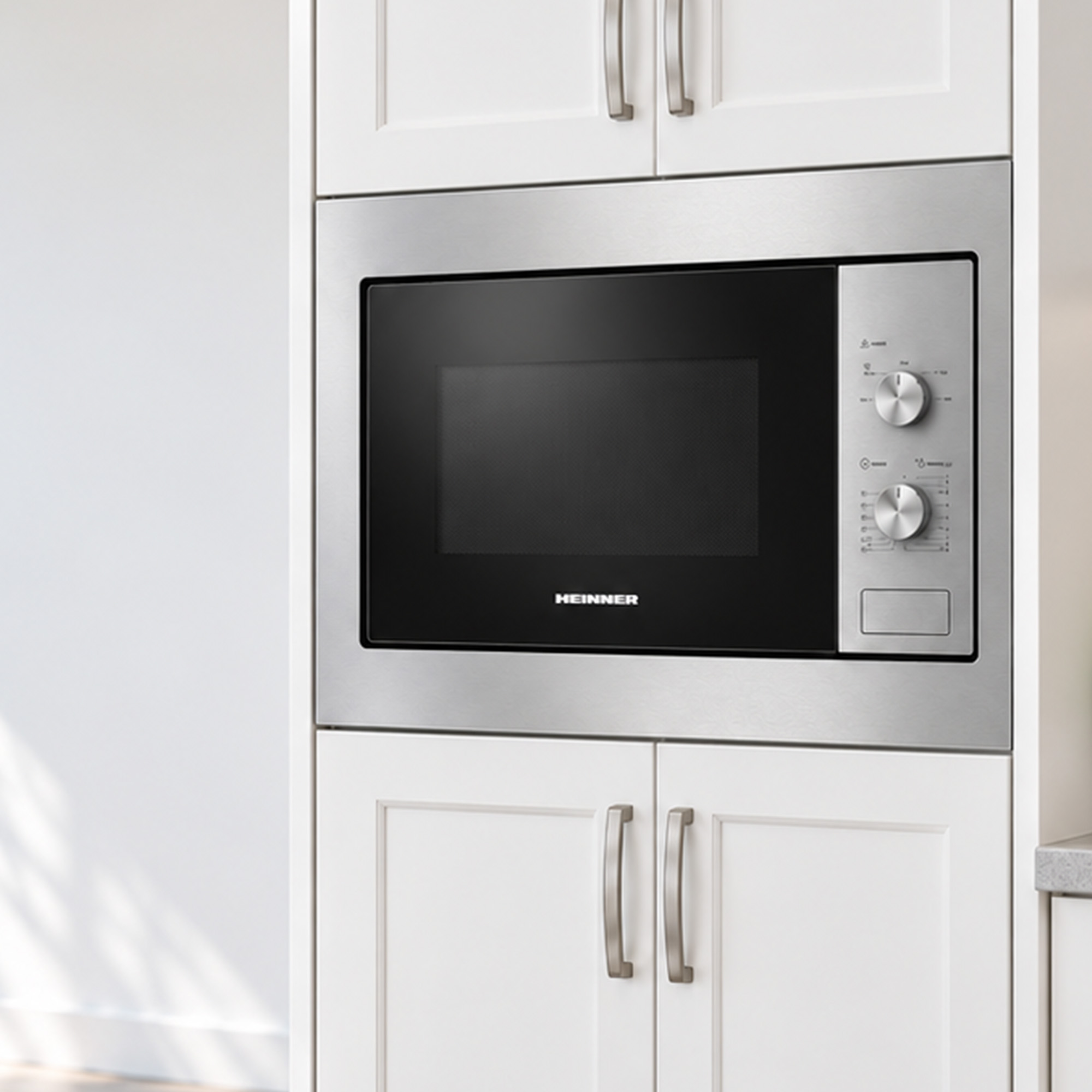 Built-in Heinner microwave with silver trim and knobs set between white kitchen cabinets.