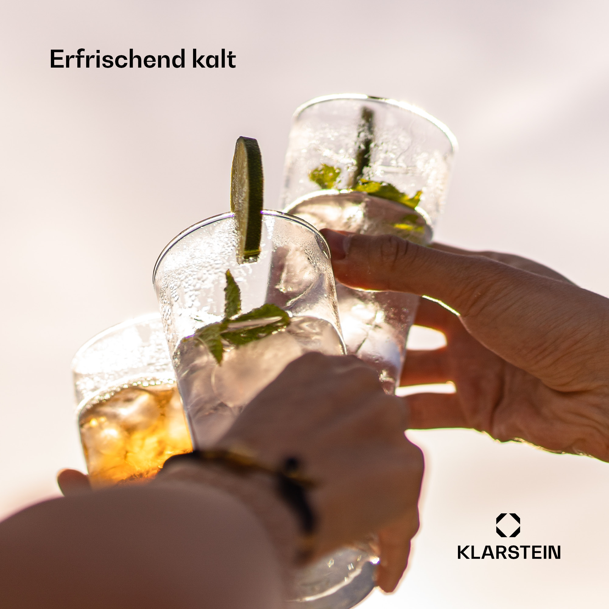 Drei Personen stoßen mit erfrischenden Cocktails mit Minze und Limette an.
