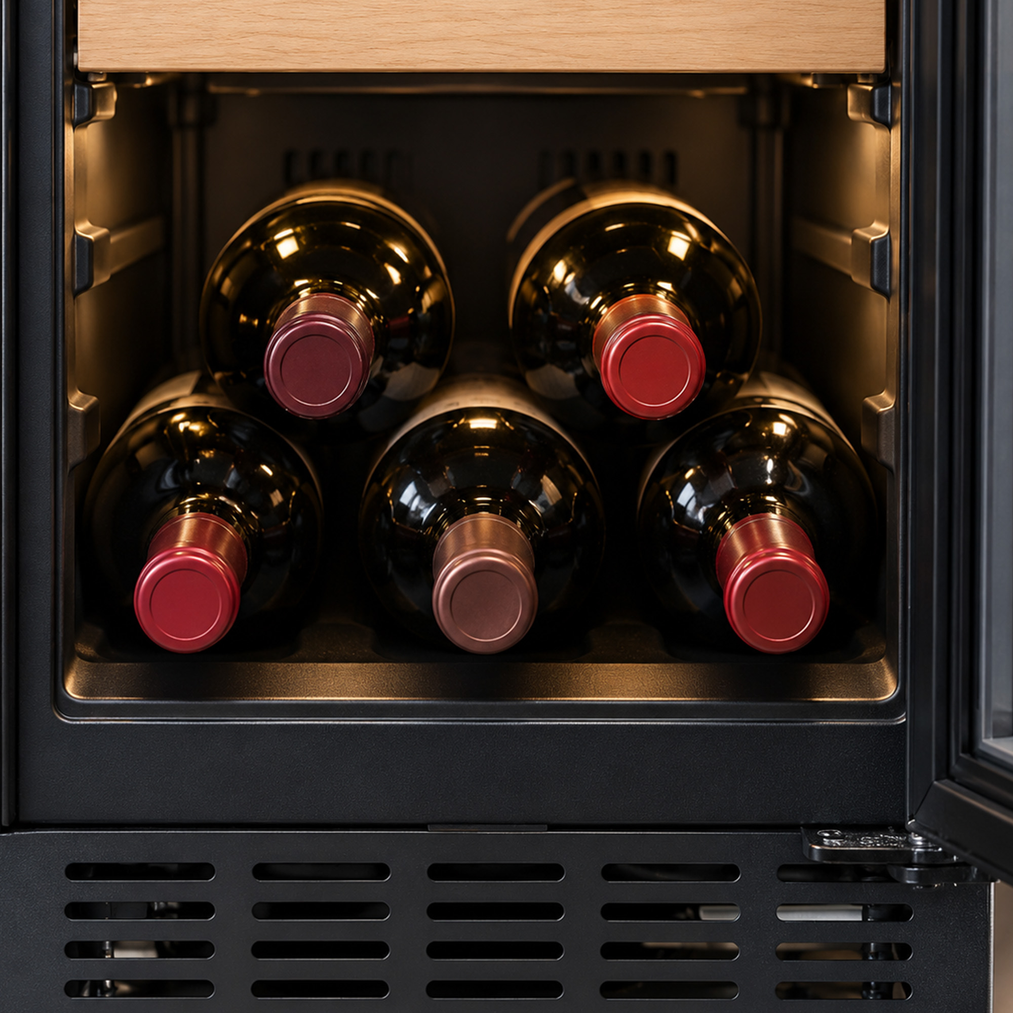Five wine bottles are stored inside a warm, well-lit wine cooler.