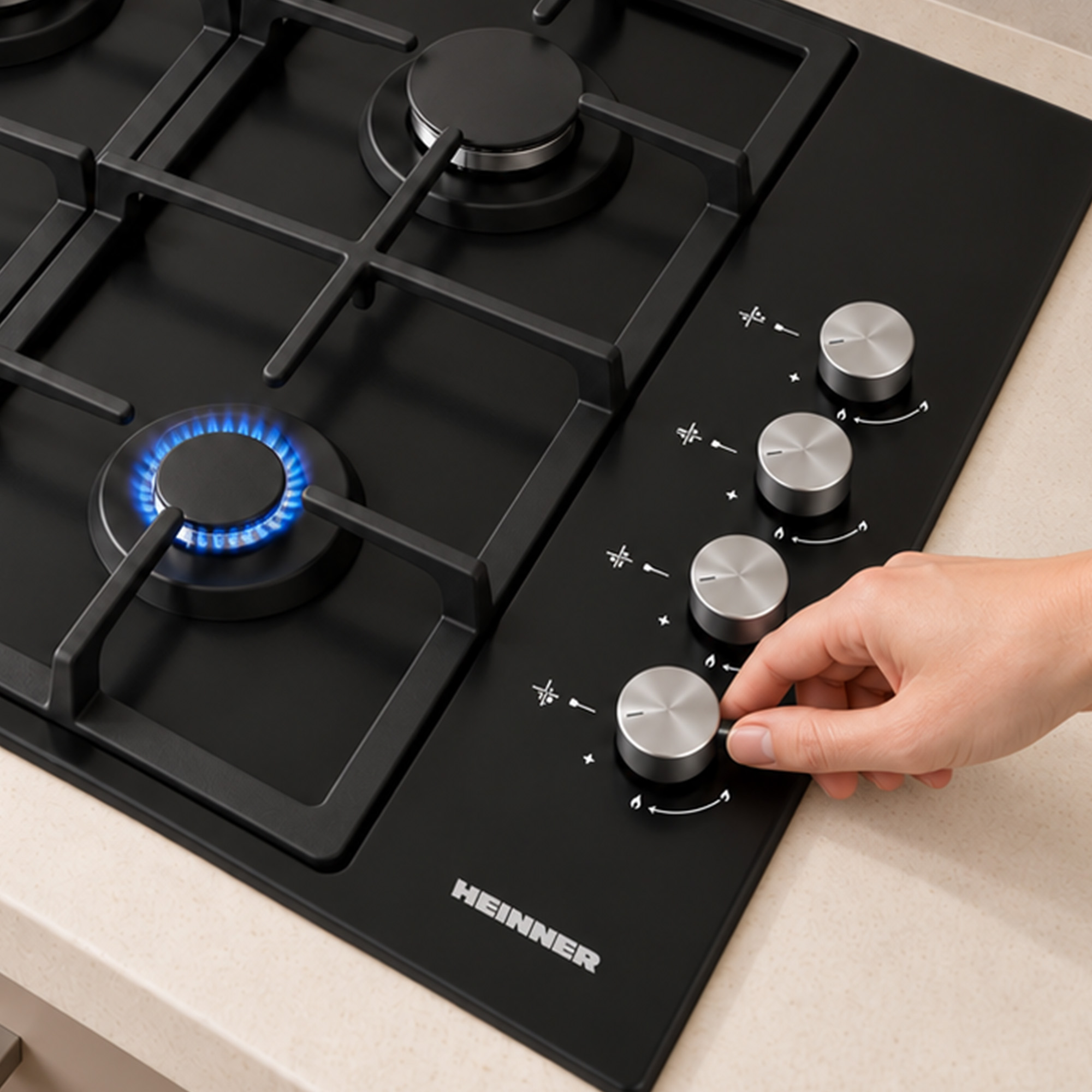 Hand turning the silver knob of a black gas hob with a lit blue flame.