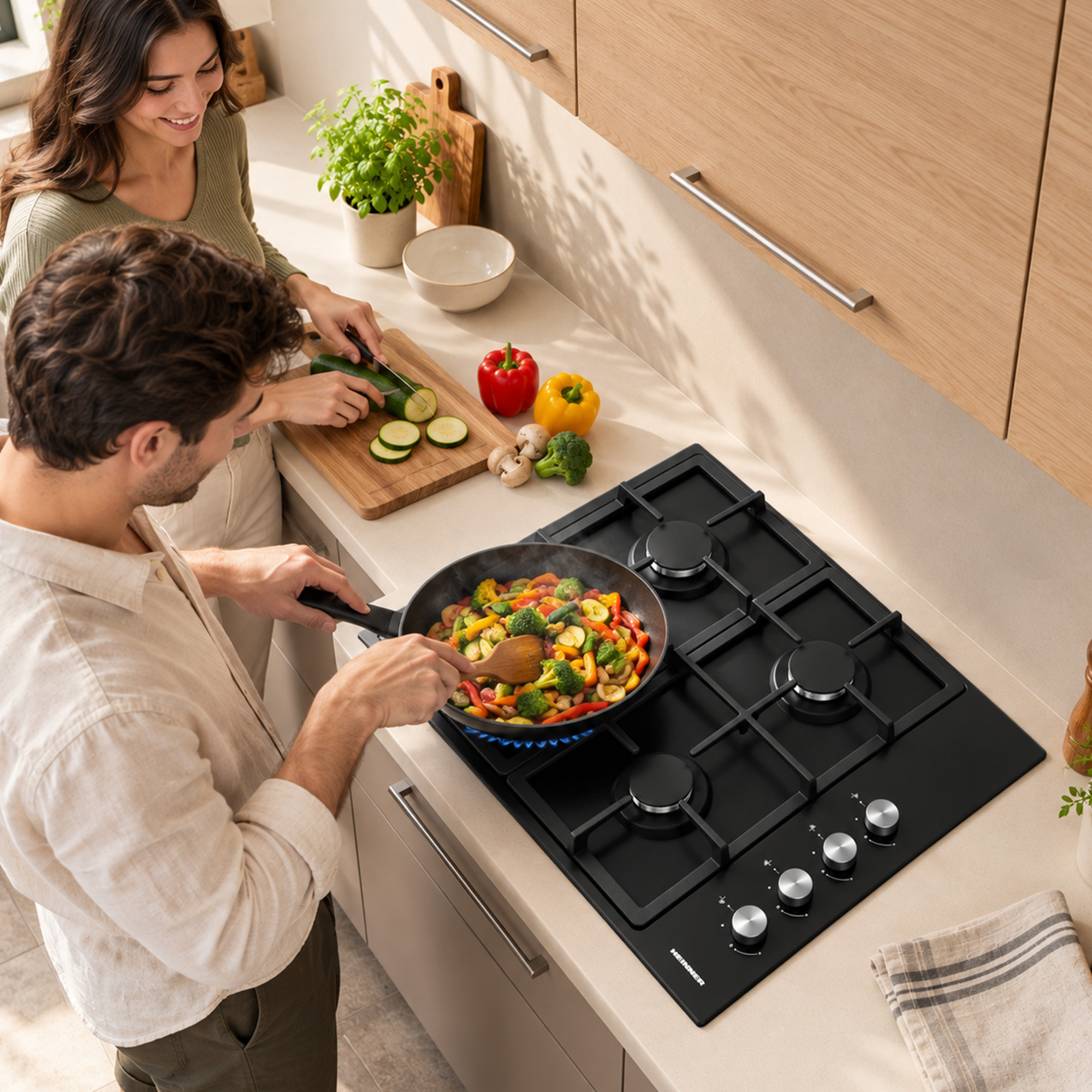 A couple cooking in a bright kitchen. A man stirs vegetables in a pan while a woman slices vegetables on a cutting board.