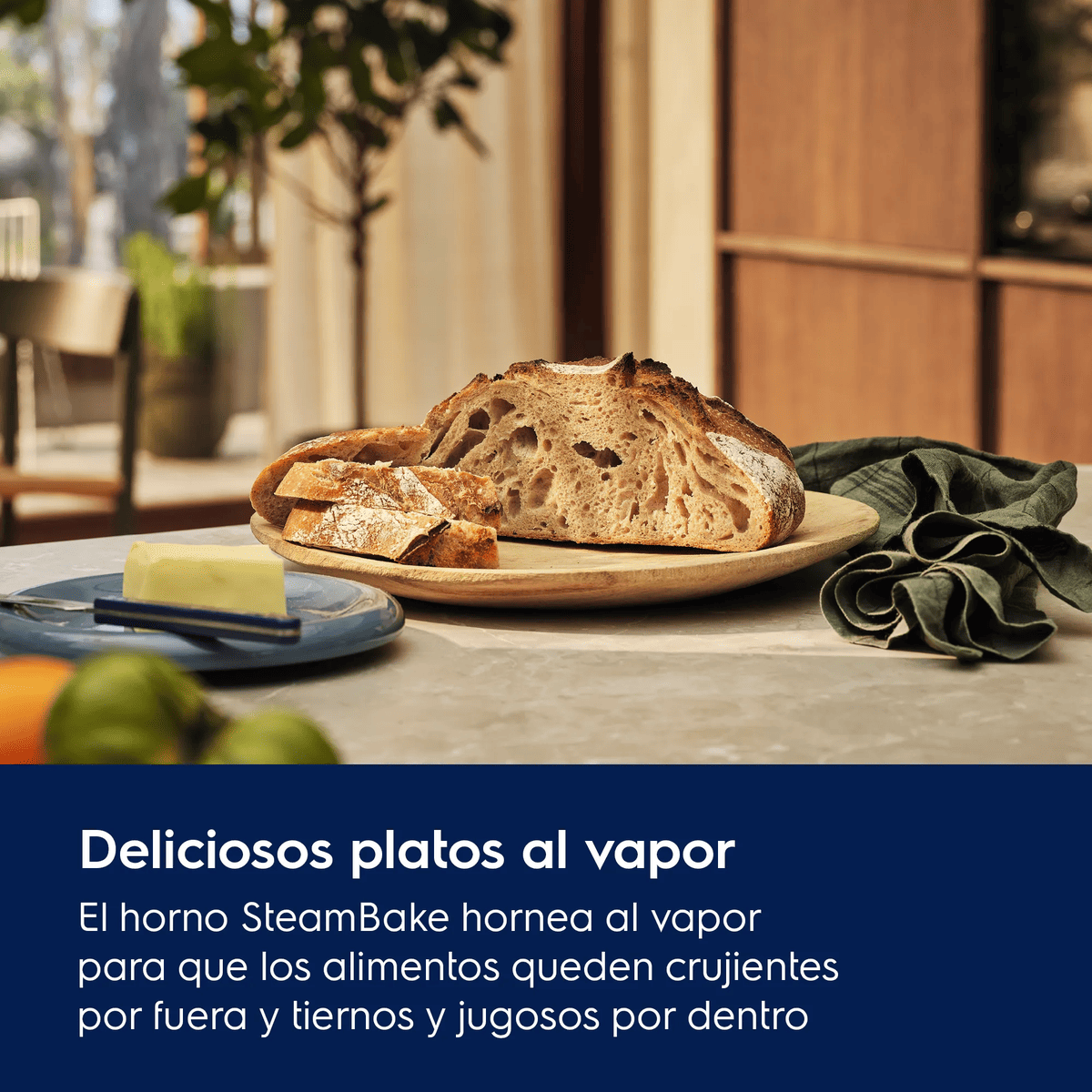 Pan recién horneado y mantequilla en un plato de madera en una cocina, con texto en el área azul inferior.