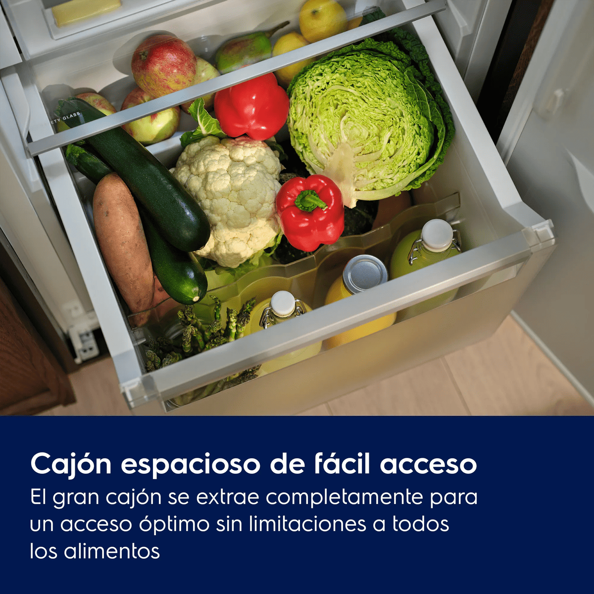 Un cajón de refrigerador abierto lleno de verduras, fruta y botellas.