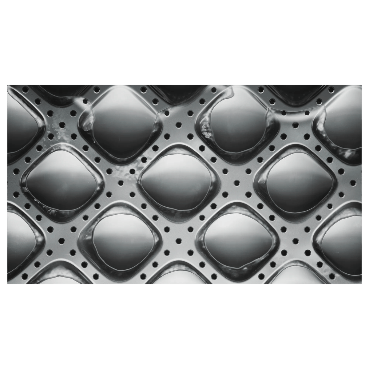 Primer plano del tambor de una lavadora gris con patrón de rombos y agujeros.