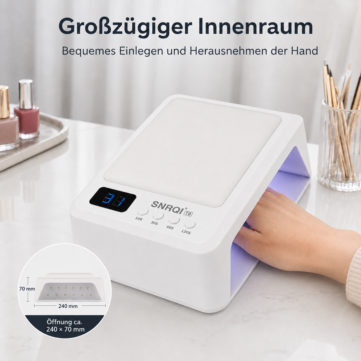 Weißes LED-Nageltrocknungsgerät mit digitaler Anzeige und Hand im Inneren auf weißem Tisch.