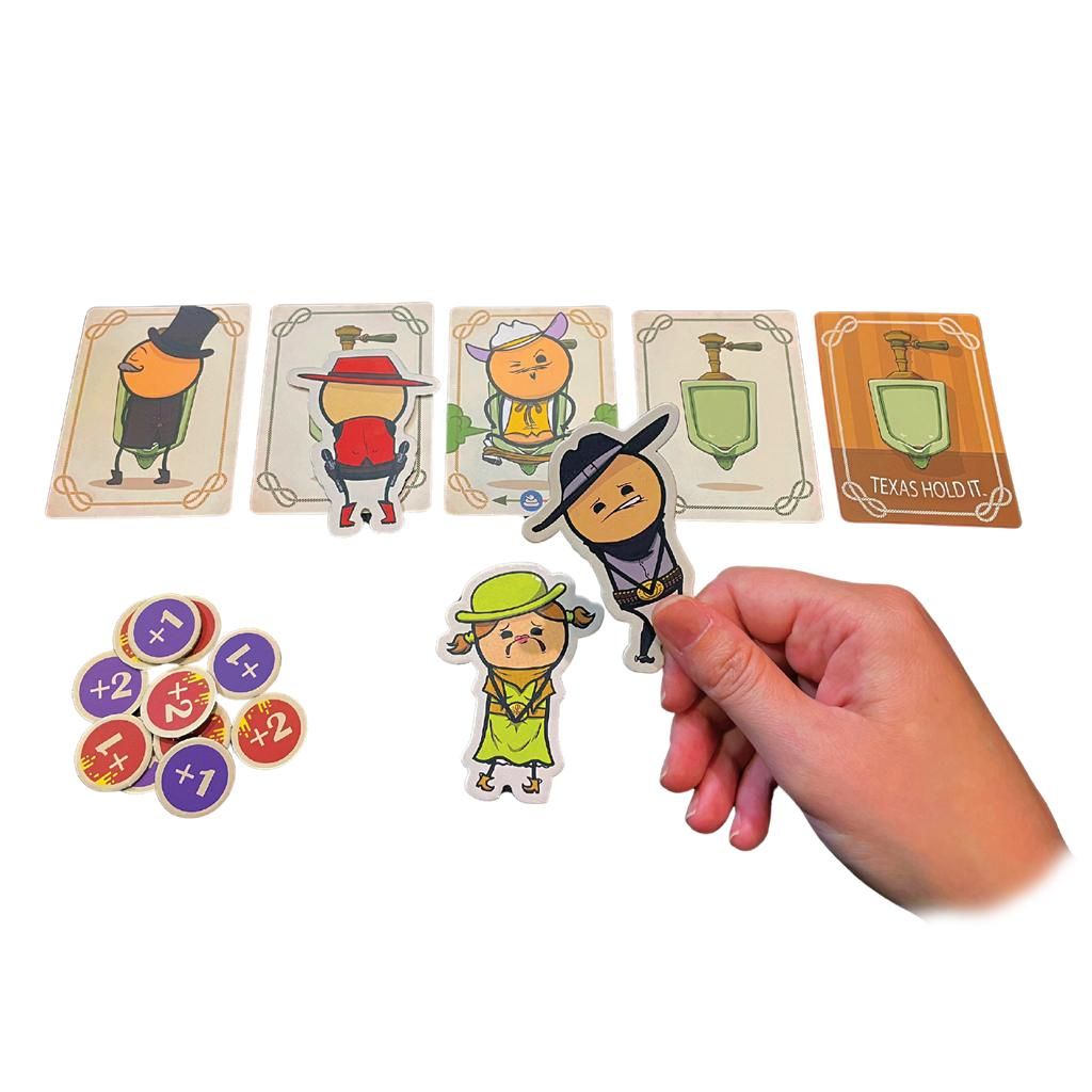 Mano sosteniendo ficha de juego sobre mesa con cartas y fichas.