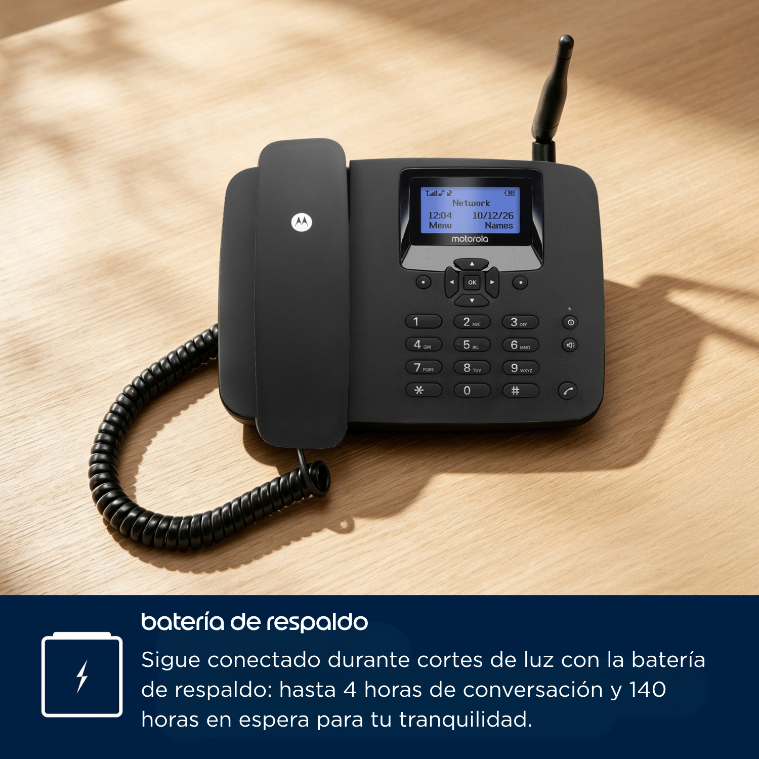 Un teléfono de escritorio negro Motorola con pantalla y antena sobre una mesa de madera.