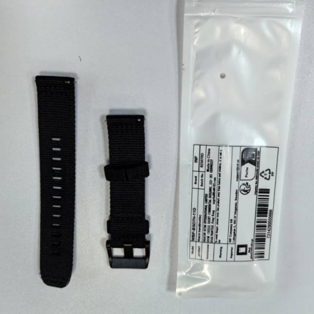 Due cinturini per orologio in nylon nero accanto a una confezione.