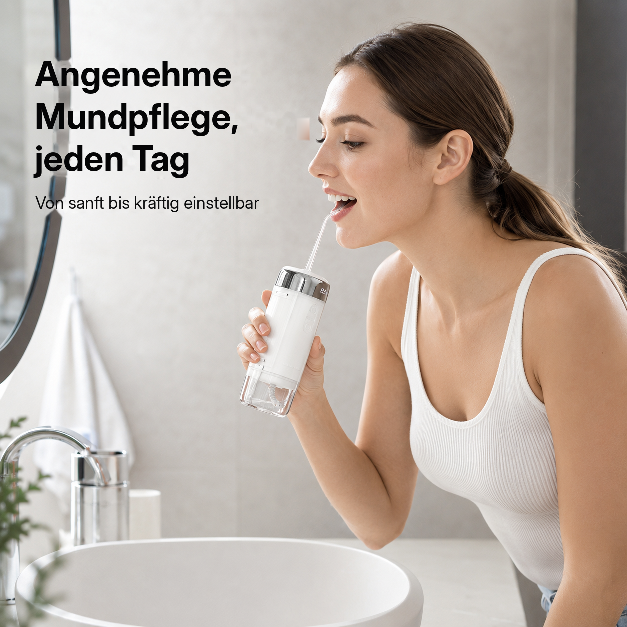 Eine Frau benutzt eine weiße Munddusche vor einem Waschbecken im Badezimmer.