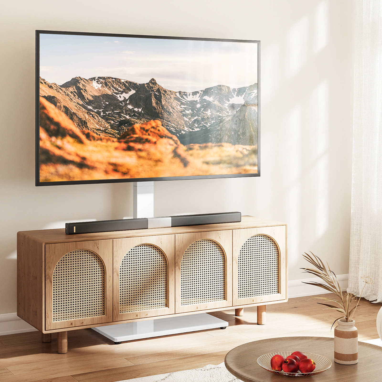 Ein großer Fernseher auf einem Ständer mit Bergen über einem Holzkastenschrank mit Rattantüren im Wohnzimmer.